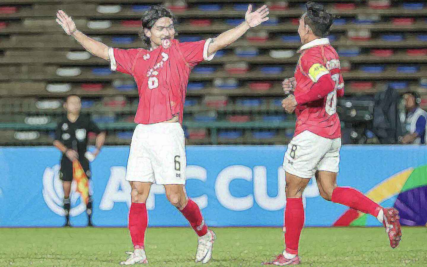 Celebration scene: The image captures a moment of celebration or interaction between two soccer players on the field. They are both wearing red jerseys with the logo of Phnom Penh Crown FC, white shorts, and red socks. One player has his arms wide open while facing the other player who is approaching him with his right arm raised. Their faces show the happines in this image